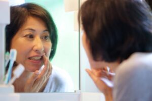 鏡で歯茎の様子を確認している女性