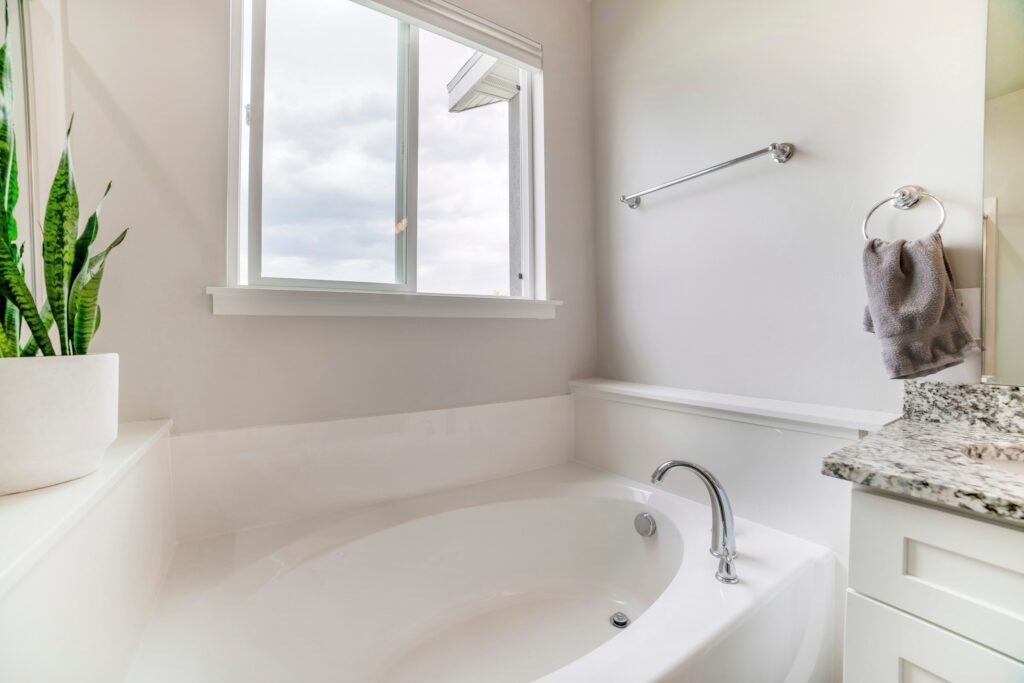 窓から光が差し込む白基調の浴室