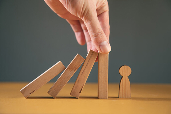 積み木が倒れないように手でおさえている