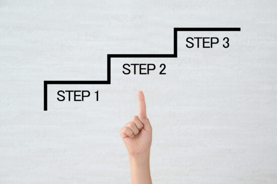 宙に浮かぶSTEPを指差す子供の手