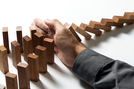 積み木が倒れるのを手でおさえている