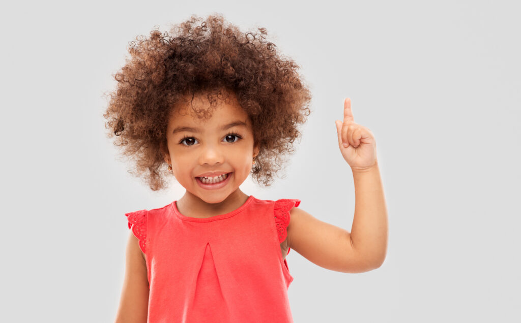 人差し指を天に突き上げる少女