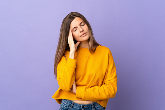 頭をかしげて悩んでいる女性