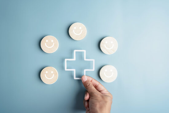 プラスマークを並べる男性の手元