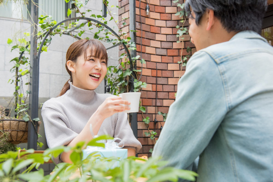テラスでお茶を楽しむ笑顔の男女