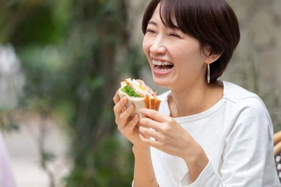 根管治療をして笑顔で食事をする女性
