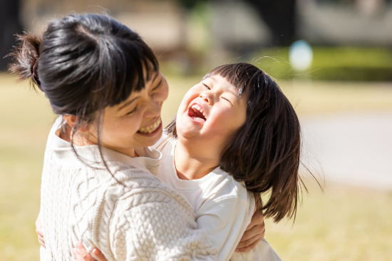 母親に抱きつく笑顔の子ども