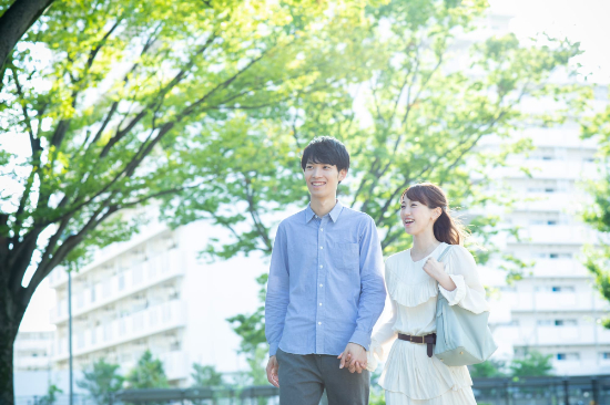 手を繋いで公園を歩くカップル