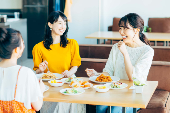 友人と外食を楽しんでいるマウスピース矯正中の女性