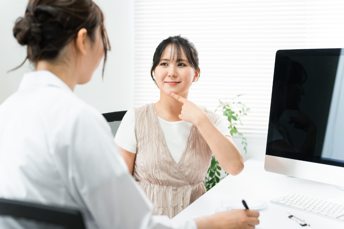 受け口の女性が歯科医師に相談している