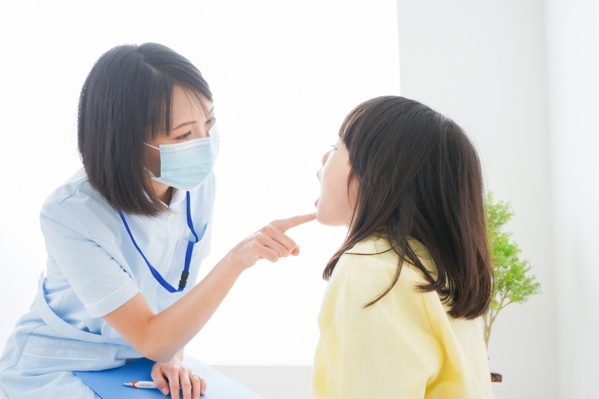 口の体操をする歯科医と子ども